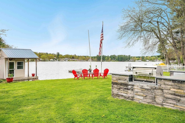 view of yard with exterior kitchen and a water view