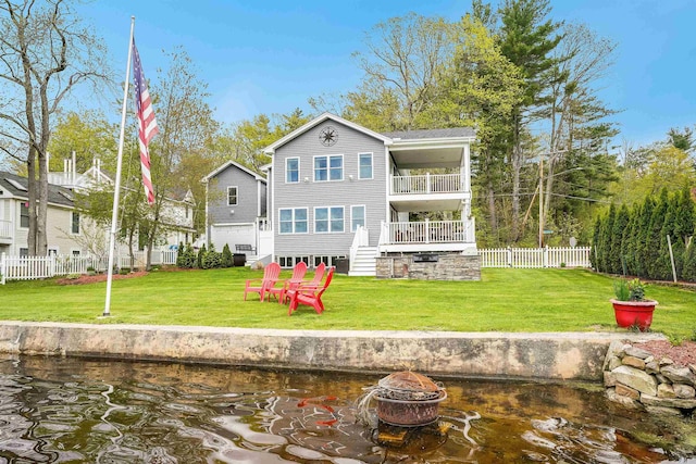 back of property with an outdoor fire pit, a balcony, stairs, and a water view