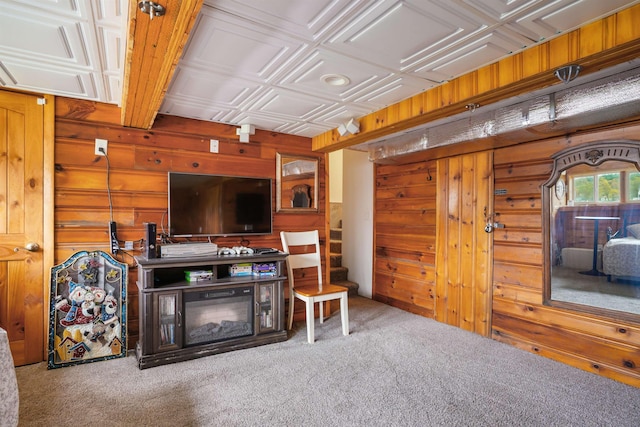 carpeted living area with wooden walls