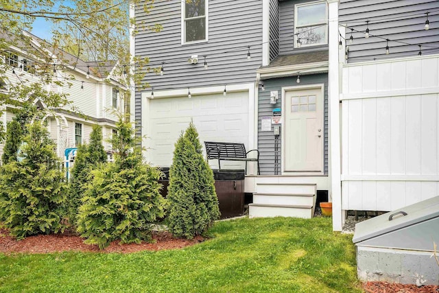 property entrance featuring a lawn and an attached garage