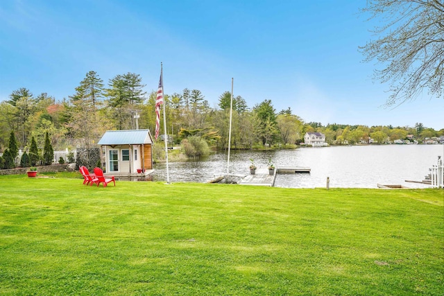 view of grassy yard featuring a water view and a boat dock