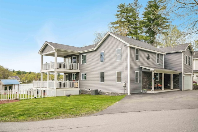 view of property exterior with asphalt driveway, a balcony, and cooling unit
