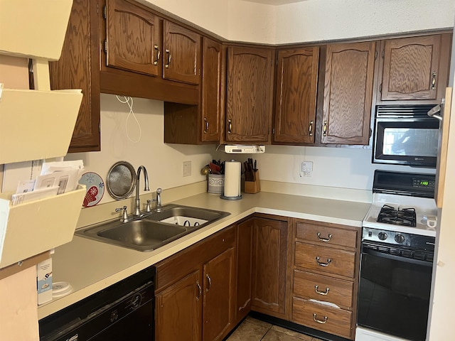 kitchen with black appliances, a sink, light countertops, and light tile patterned floors