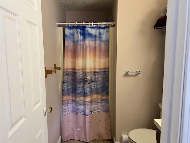 full bath with a textured ceiling, vanity, toilet, a shower with shower curtain, and baseboards