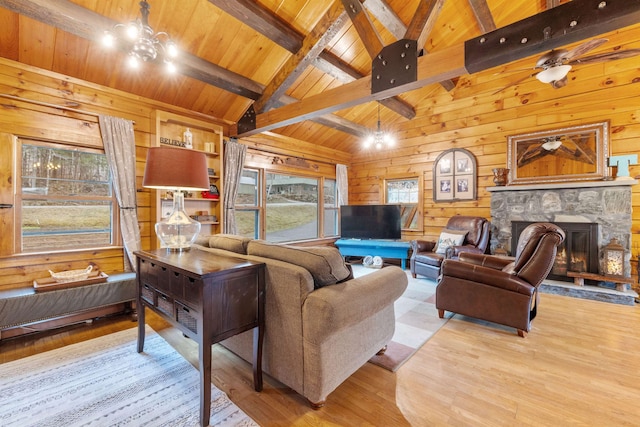 living area with wood walls, hardwood / wood-style floors, wood ceiling, and a stone fireplace