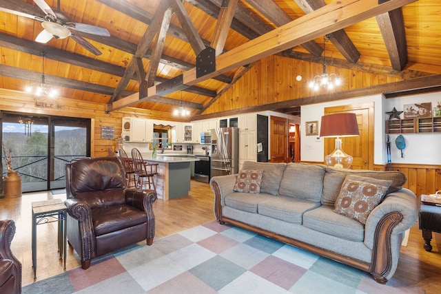 living room featuring wood ceiling, wood walls, ceiling fan, a chandelier, and light floors