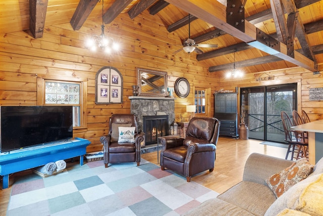 living room featuring wood walls, wooden ceiling, a fireplace, tile patterned floors, and a ceiling fan