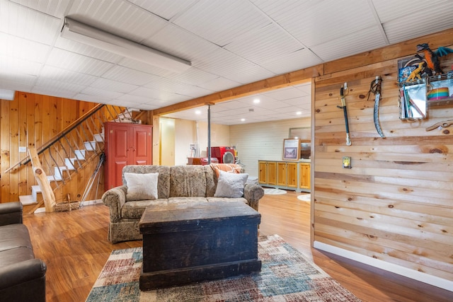 living area featuring wooden walls, stairway, wood finished floors, and recessed lighting