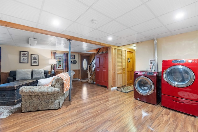 laundry room with washing machine and clothes dryer and wood finished floors