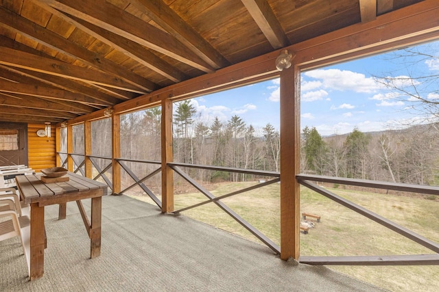 unfurnished sunroom featuring a forest view