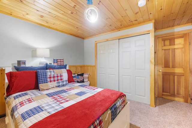 bedroom featuring carpet flooring, wainscoting, wooden ceiling, wooden walls, and a closet