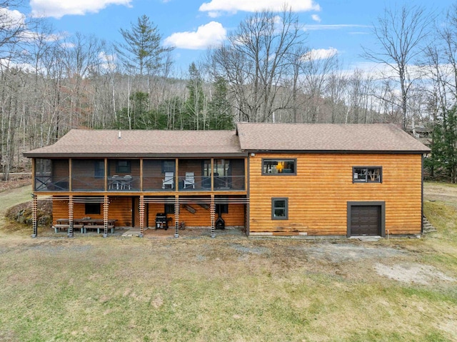 view of front of property with roof with shingles, a sunroom, and a garage