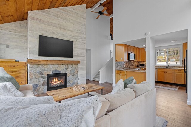 28 Fox Run Rd Unit 1And 2, Lincoln, NH 03251 - living room with wooden ceiling, high vaulted ceiling, a stone fireplace, a ceiling fan, and stairway