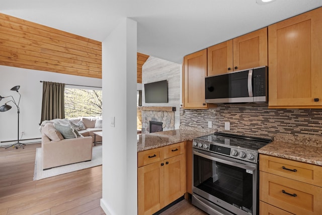 28 Fox Run Rd Unit 1And 2, Lincoln, NH 03251 - kitchen featuring stainless steel appliances, open floor plan, tasteful backsplash, a fireplace, and vaulted ceiling