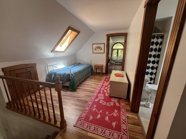 bedroom featuring wood finished floors and lofted ceiling
