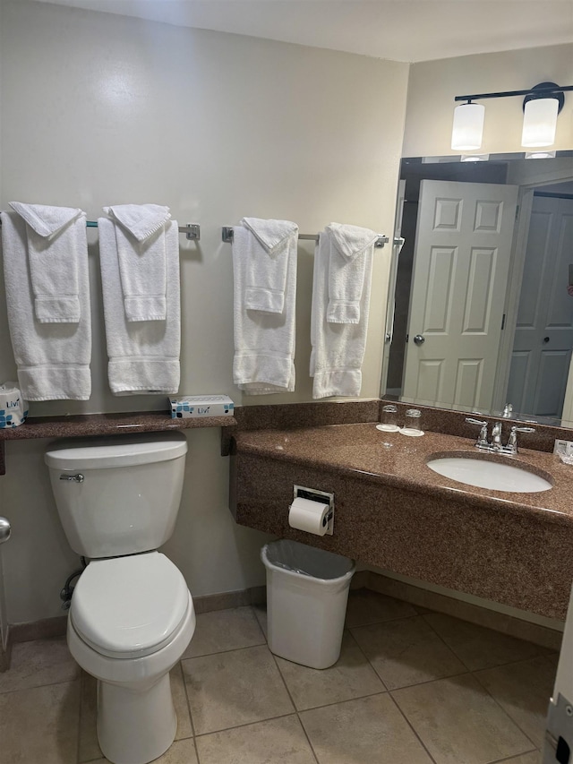 bathroom with a sink, tile patterned floors, toilet, and baseboards