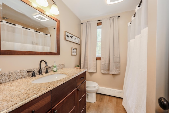 81 Spaulding Rd, Fremont, NH 03044 - full bathroom featuring a baseboard heating unit, wood finished floors, toilet, vanity, and baseboards