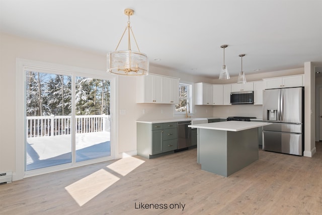 74 Willow Way, Georgia, VT 05468 - kitchen featuring stainless steel appliances, a chandelier, a kitchen island, light countertops, and light wood-style flooring