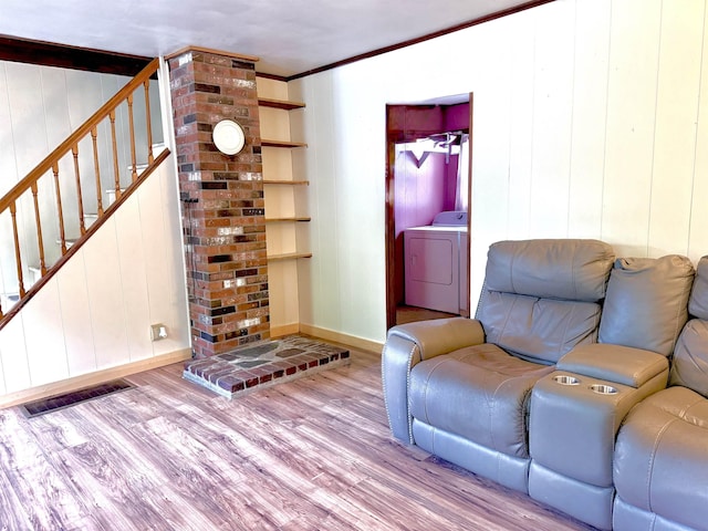 living room with washer / clothes dryer, wood finished floors, stairway, baseboards, and crown molding