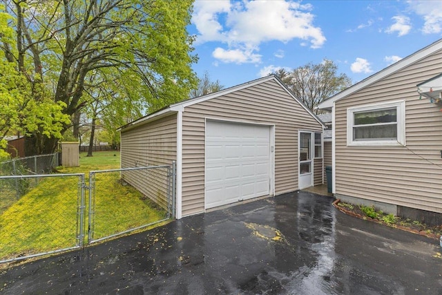 173 Tracy Dr, Burlington, VT 05408 - detached garage featuring asphalt driveway, a gate, and fence
