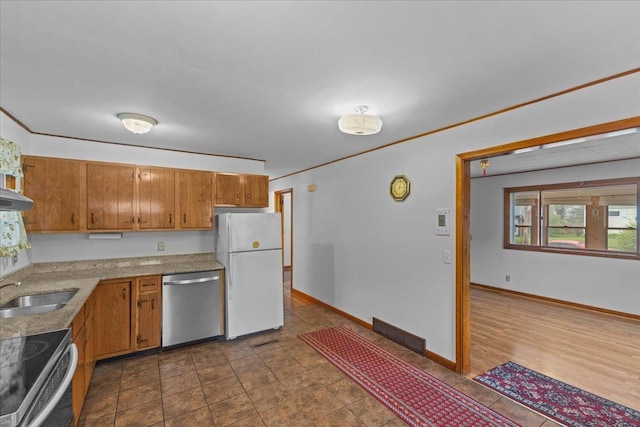 173 Tracy Dr, Burlington, VT 05408 - kitchen featuring stainless steel appliances, a sink, brown cabinetry, and baseboards