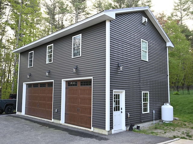 view of side of home featuring a garage and driveway