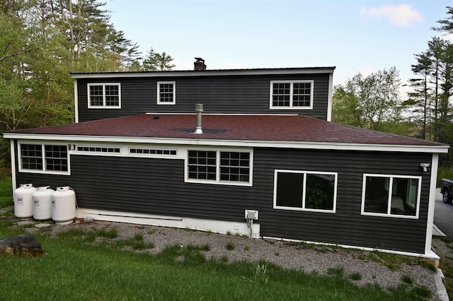back of property with a chimney and a shingled roof