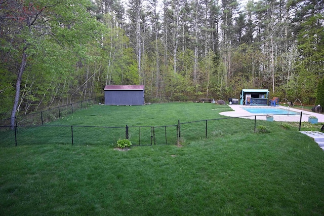 view of yard featuring a shed, an outdoor structure, and a view of trees