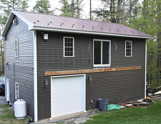 back of property with metal roof and a garage
