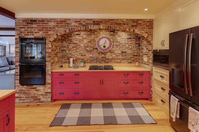 406 Partridge Lake Rd, Littleton, NH 03561 - kitchen featuring black appliances, light wood-style flooring, and brick wall