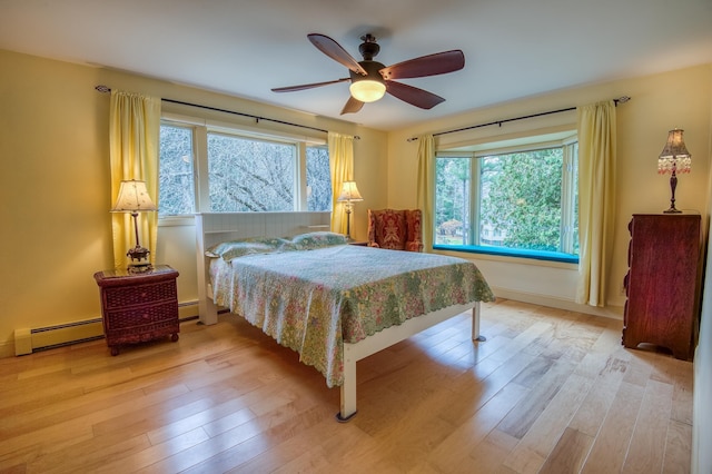 406 Partridge Lake Rd, Littleton, NH 03561 - bedroom featuring a baseboard radiator, light wood finished floors, a ceiling fan, and baseboards