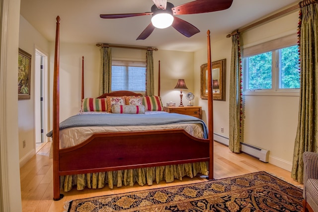406 Partridge Lake Rd, Littleton, NH 03561 - bedroom featuring wood finished floors, a baseboard radiator, a ceiling fan, and baseboards