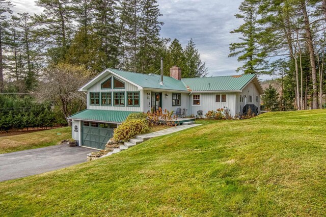 406 Partridge Lake Rd, Littleton, NH 03561 - back of property with a chimney, driveway, metal roof, and a garage