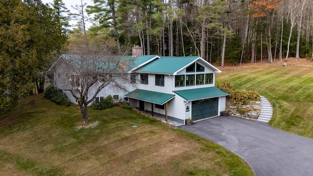 406 Partridge Lake Rd, Littleton, NH 03561 - view of front facade with a chimney, a garage, a front yard, metal roof, and driveway