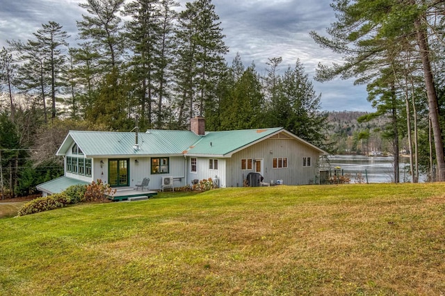406 Partridge Lake Rd, Littleton, NH 03561 - back of house with a chimney, a lawn, metal roof, and a deck with water view
