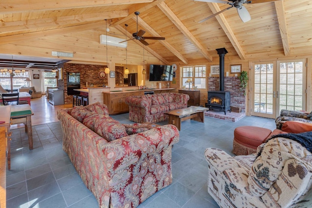 406 Partridge Lake Rd, Littleton, NH 03561 - living room with a wood stove, a ceiling fan, wood ceiling, healthy amount of natural light, and beamed ceiling