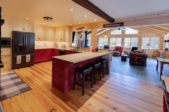 406 Partridge Lake Rd, Littleton, NH 03561 - kitchen with black appliances, open floor plan, a breakfast bar area, a peninsula, and backsplash
