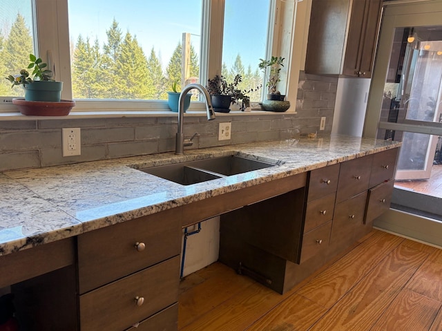 1202 Cotton Rd, Lyndon, VT 05851 - kitchen with a sink, tasteful backsplash, light stone counters, and light wood-style floors