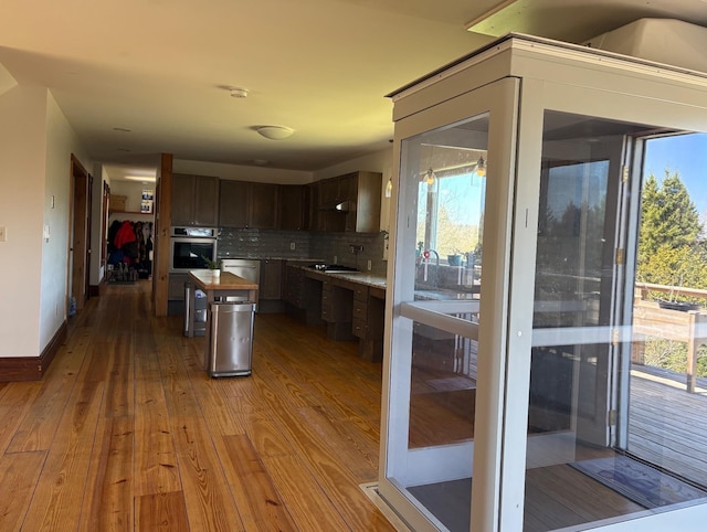 1202 Cotton Rd, Lyndon, VT 05851 - kitchen with stainless steel appliances, hardwood / wood-style flooring, backsplash, dark brown cabinets, and a kitchen island