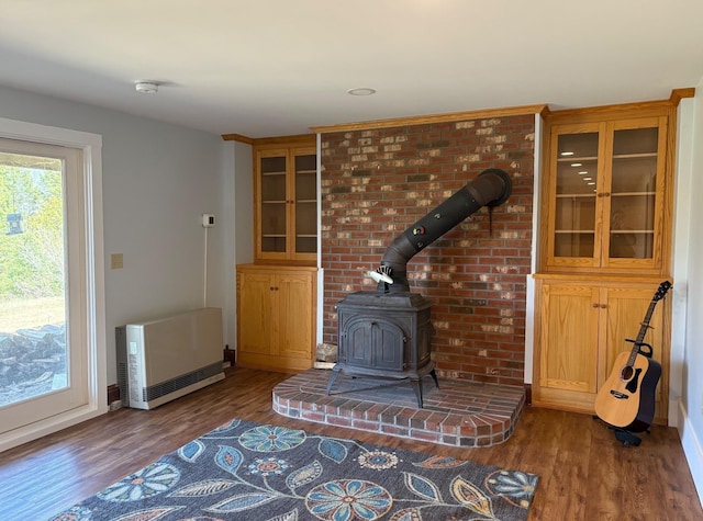 1202 Cotton Rd, Lyndon, VT 05851 - unfurnished living room featuring heating unit, a wood stove, wood finished floors, and baseboards