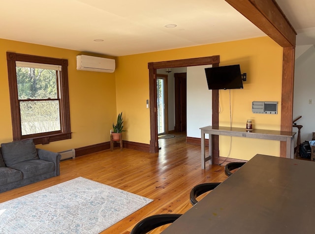1202 Cotton Rd, Lyndon, VT 05851 - living area featuring a wall mounted AC, wood finished floors, baseboards, and a baseboard heating unit