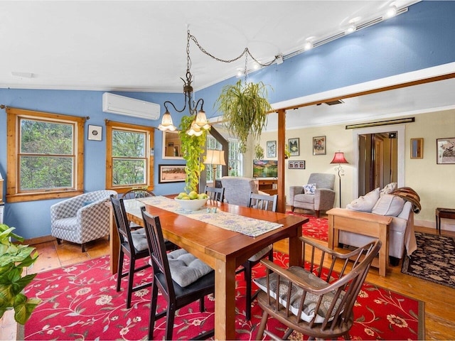 dining area with a wall unit AC, wood finished floors, a chandelier, ornamental molding, and baseboards