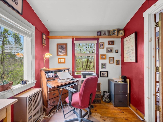 office with hardwood / wood-style flooring, healthy amount of natural light, and baseboards