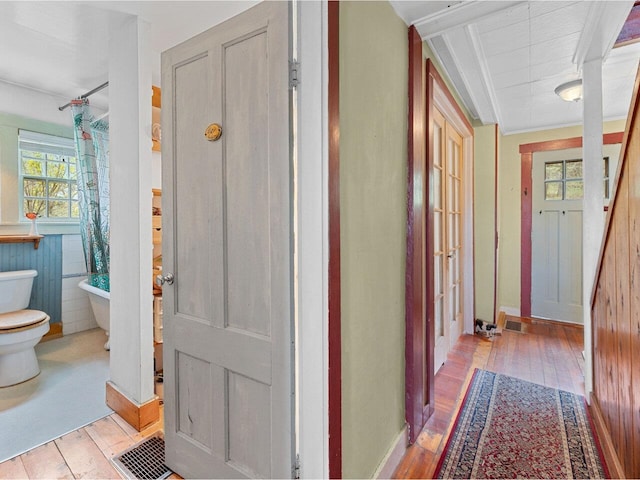 hall featuring hardwood / wood-style flooring and baseboards