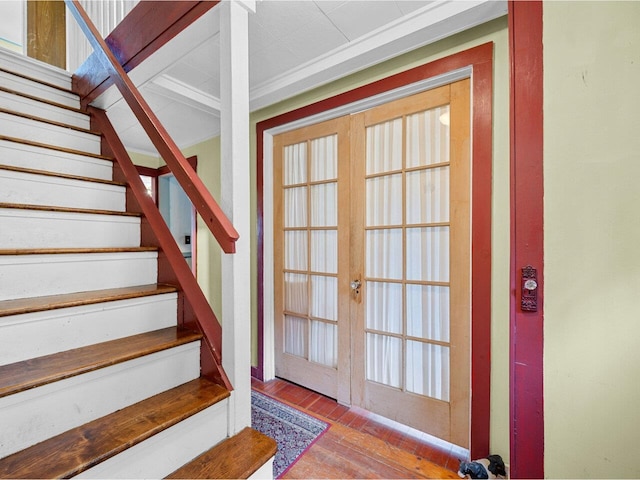 staircase featuring wood finished floors and french doors
