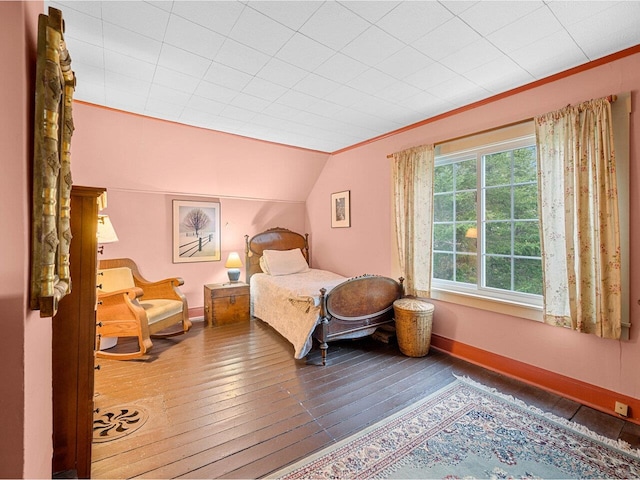 bedroom featuring wood-type flooring, baseboards, and lofted ceiling