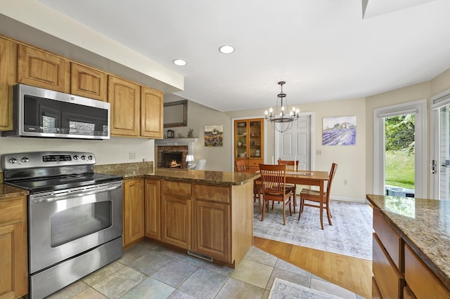 17 Ches Mae Ln, Milford, NH 03055 - kitchen featuring appliances with stainless steel finishes, a fireplace, a chandelier, recessed lighting, and dark stone countertops
