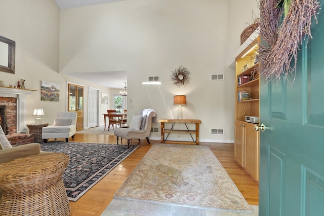 17 Ches Mae Ln, Milford, NH 03055 - foyer with a high ceiling, baseboards, a fireplace, light wood-type flooring, and a chandelier