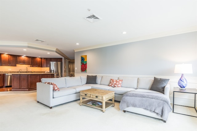 living area with crown molding, a wainscoted wall, recessed lighting, light carpet, and bar with sink
