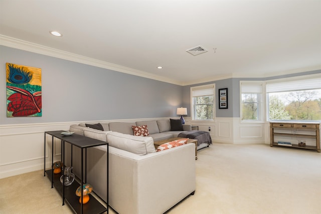 living room featuring light colored carpet, crown molding, a wainscoted wall, a decorative wall, and recessed lighting